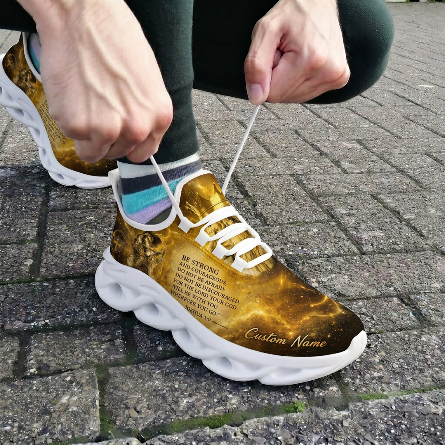 Close-up of a person tying the white laces of the custom Christian warrior sneakers while wearing them outside on brick pavement