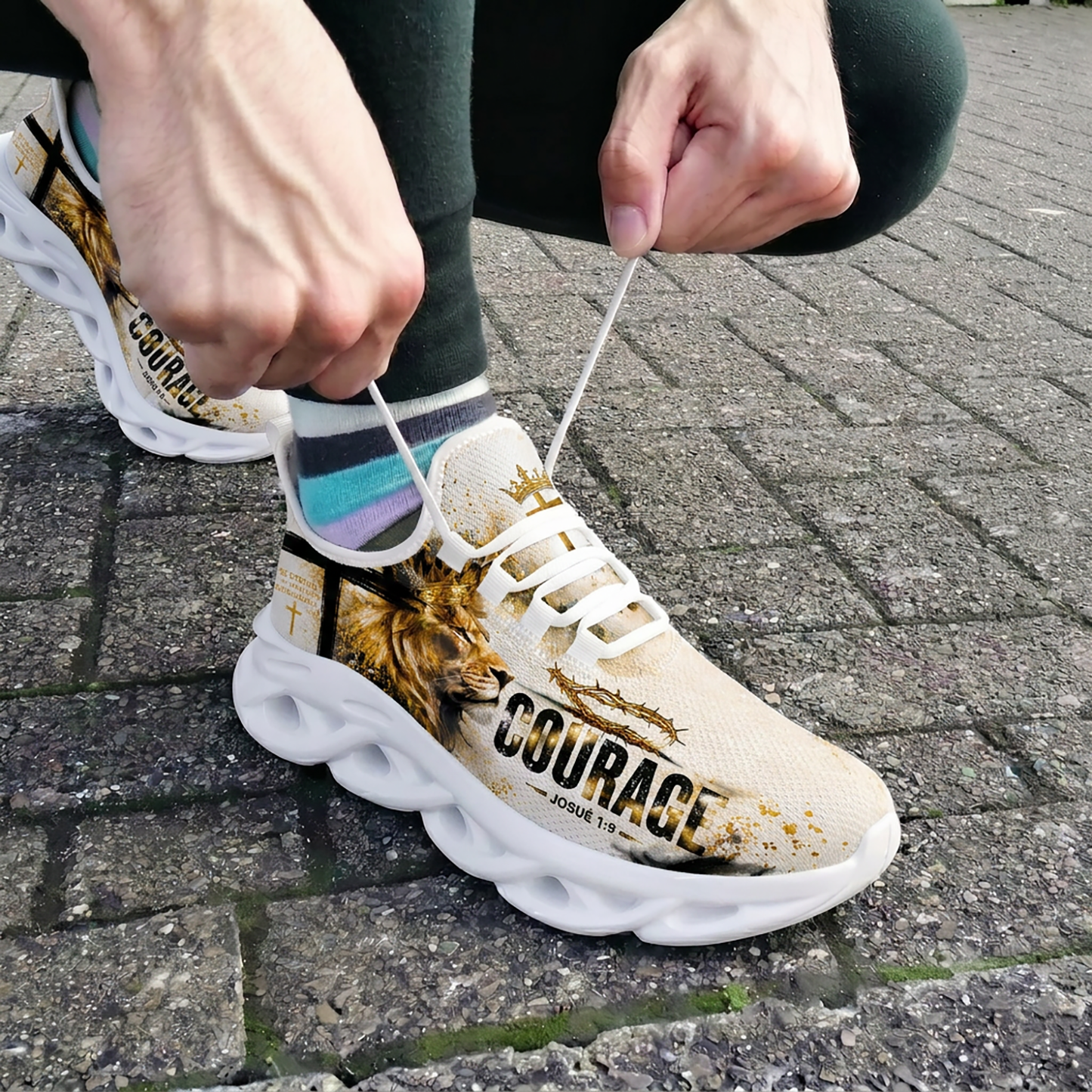 Close-up of a person tying the laces of the custom Portuguese courage sneakers while wearing them outdoors on stone pavement