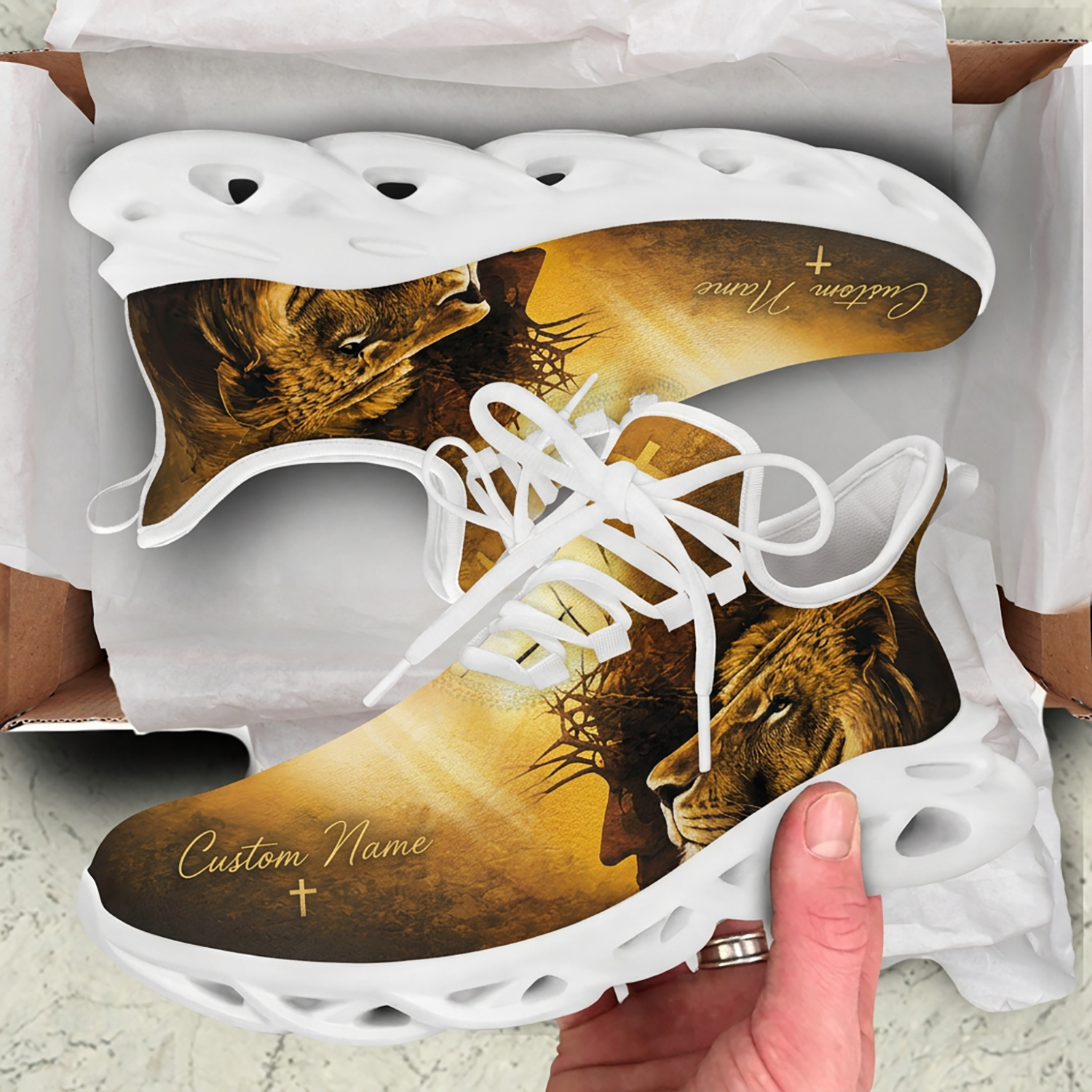 Unboxing view of Christian golden lion sneakers nested inside a cardboard shipping box with protective paper