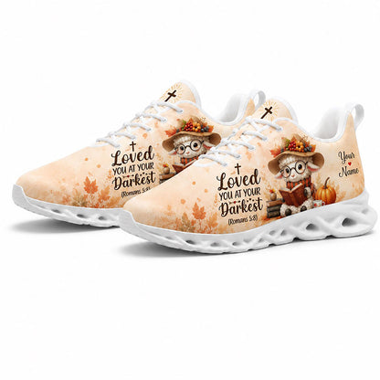 Angled view of a pair of custom autumn lamb sneakers with orange fall leaves and Romans 5:8 scripture on white soles