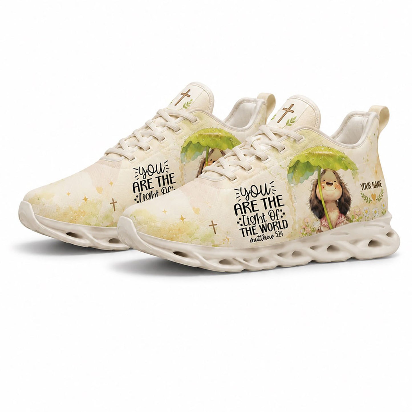 Angled pair of cream Christian sneakers with cursive script reading You Are The Light Of The World on white soles