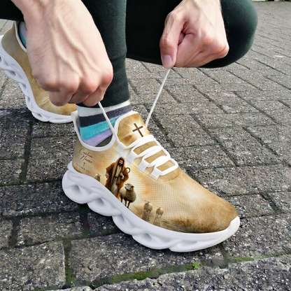 Close-up view of a person lacing up the white custom Christian shepherd athletic shoes outdoors on brick pavement