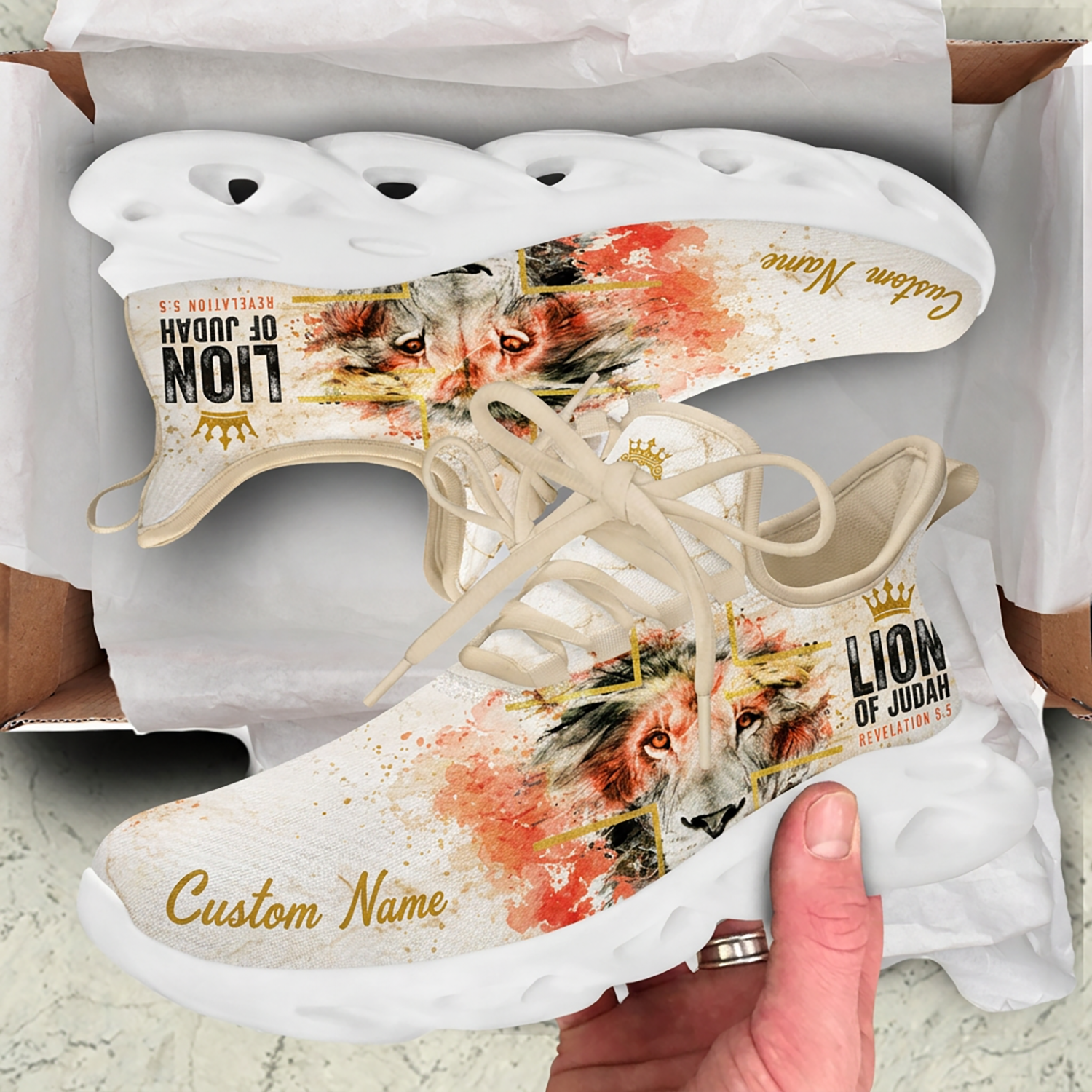 Unboxing presentation of the Christian lion splatter sneakers displayed inside a cardboard shipping box