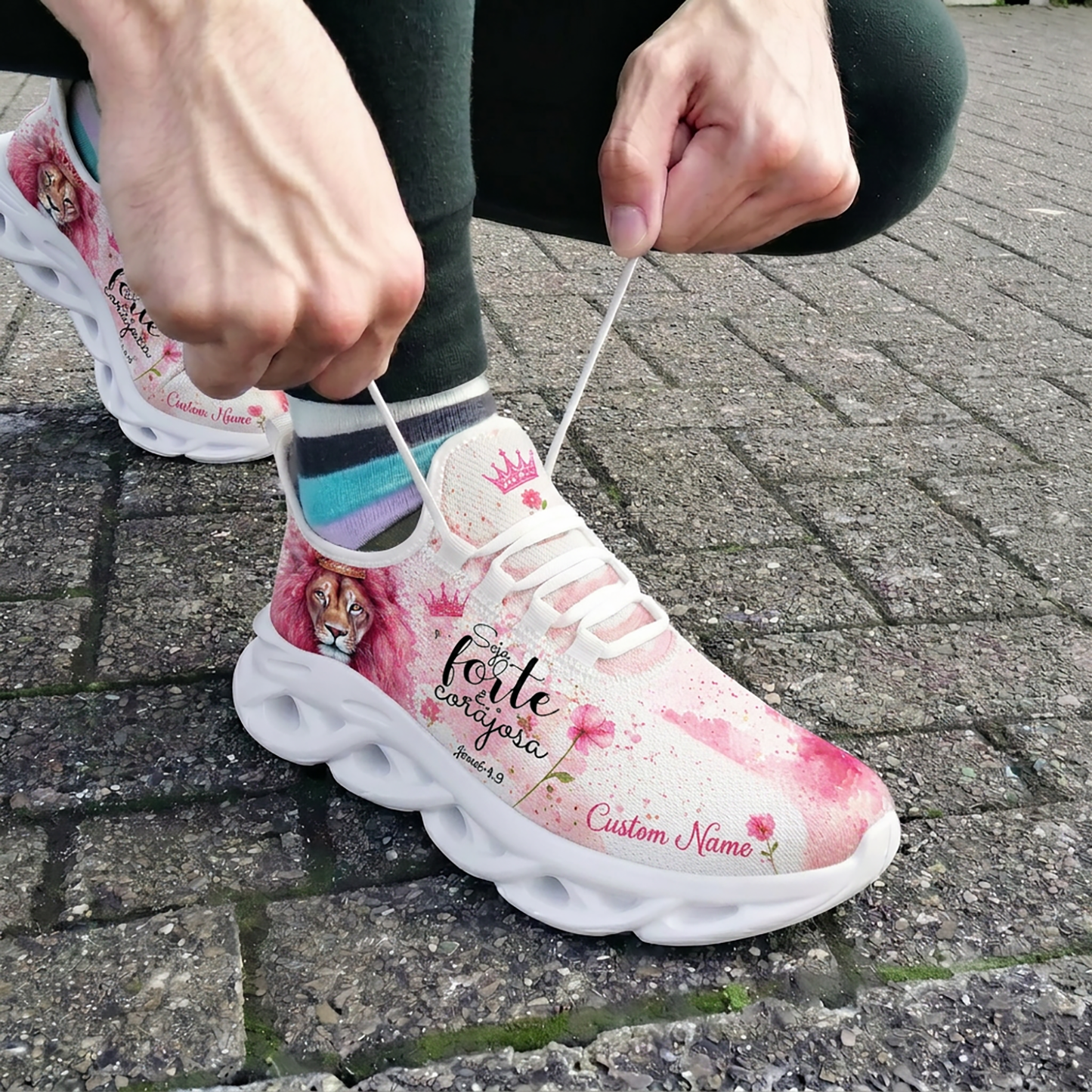 Close-up of a person tying the white laces of the custom Portuguese faith shoes while wearing them outdoors on brick pavement