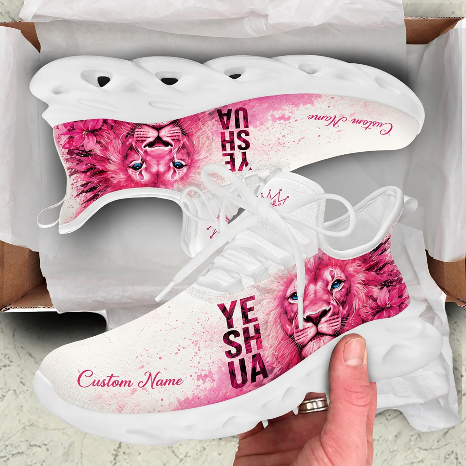 Unboxing view of pink watercolor Yeshua Christian sneakers presented inside a cardboard shipping box