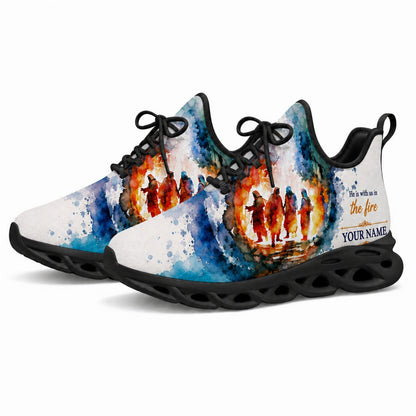Angled studio shot of black-soled religious footwear featuring the fire-faith watercolor motif