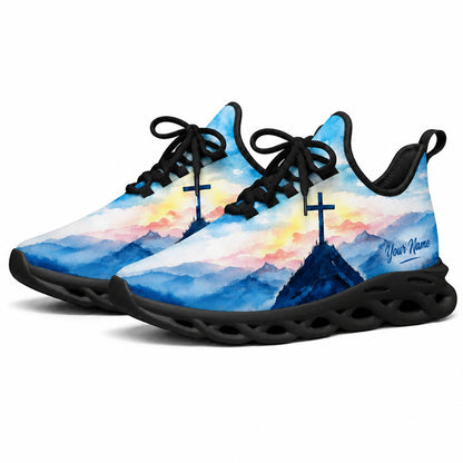 Angled studio shot of black-soled religious sneakers highlighting the serene watercolor faith scenery